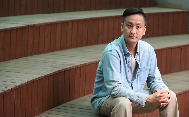 연극 <기후비상사태: 리허설>을 쓰고 연출한 전윤환 연출가가 지난 13일 오후 서울 명동예술극장에서 사진을 찍고 있다. 김정효 기자 hyopd@hani.co.kr