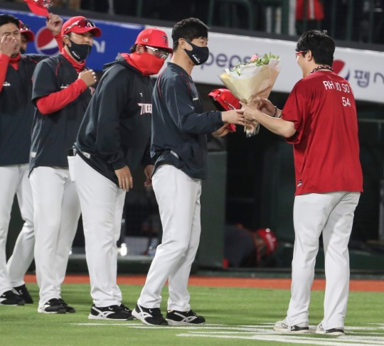 19일 사직 롯데전에서 최연소 150승을 달성한 양현종에게 김종국 감독이 축하 꽃다발을 전달하고 있다.[연합뉴스 제공]