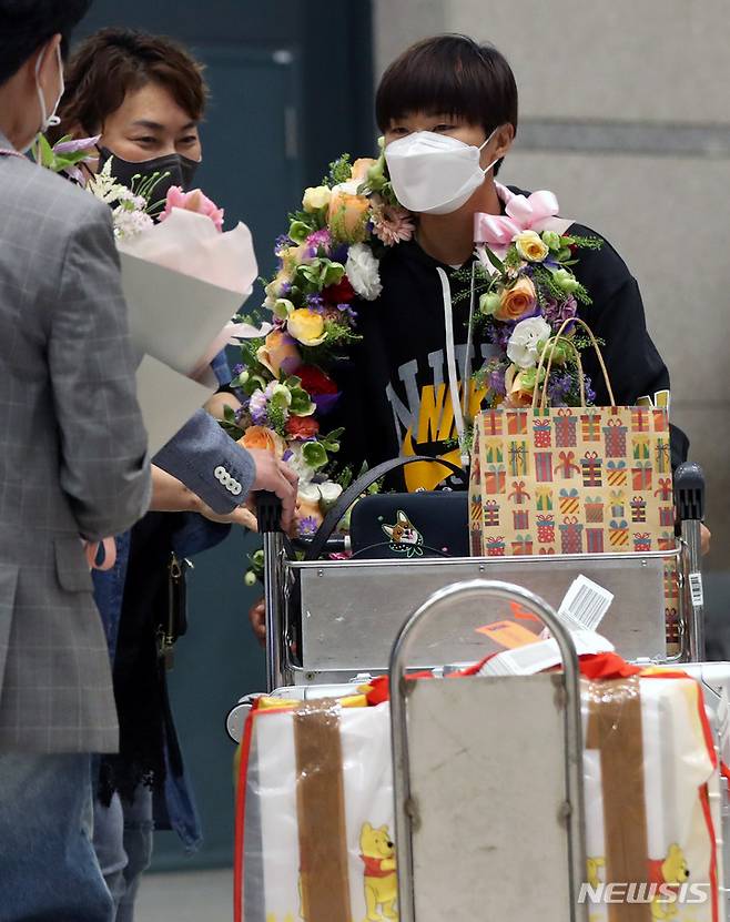 [인천공항=뉴시스] 추상철 기자 = 8년간의 영국생활을 마무리한 영국 여자 프로축구 첼시 위민에서 활약해온 지소연이 19일 오후 인천국제공항을 통해 귀국하며 가족으로 부터 꽃다발을 받고 있다. 2022.05.19. scchoo@newsis.com