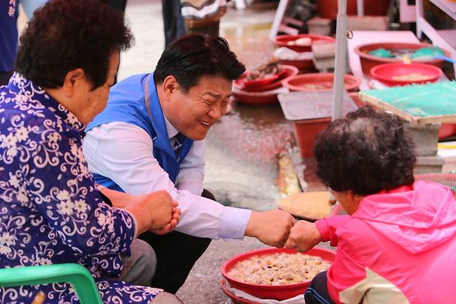 [창원=뉴시스] 홍정명 기자= 양문석 더불어민주당 경남도지사 후보가 20일 창원시 진해구 용원어시장 상인과 주먹인사를 하고 있다.(사진=양문석 선거사무소 제공) 2022.05.20. photo@newsis.com *재판매 및 DB 금지