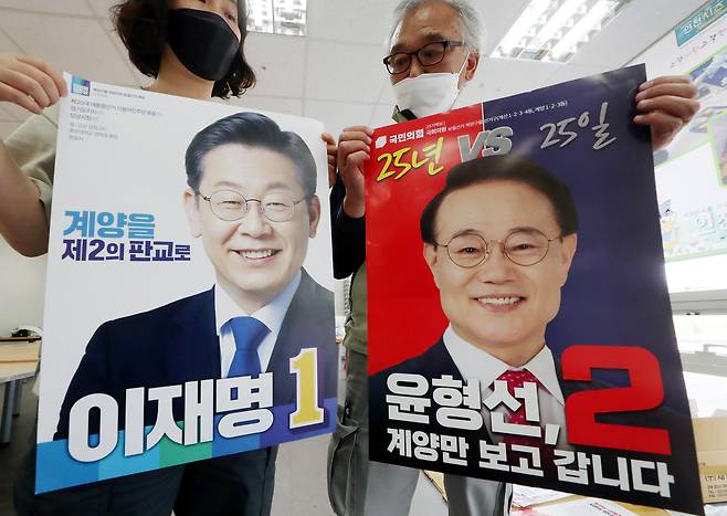 6·1 지방선거운동 개시일을 하루 앞둔 18일 오후 인천시 계양구 계양경기장 선거 벽보 분류 작업장에서 계양구 선거관리위원회 관계자들이 인천 계양을 보궐선거 더불어민주당 이재명 후보와 국민의힘 윤형선 후보의 선거 벽보를 공개하고 있다. /연하뉴스