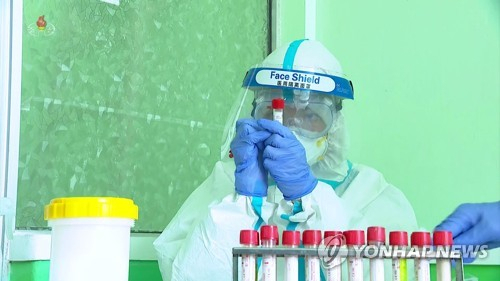 북한에서 신종 코로나바이러스 감염증(코로나19) 검사소 직원으로 보이는 사람이 중국산 안면보호구를 착용한 채 검체를 채집·분석하는 모습./연합뉴스