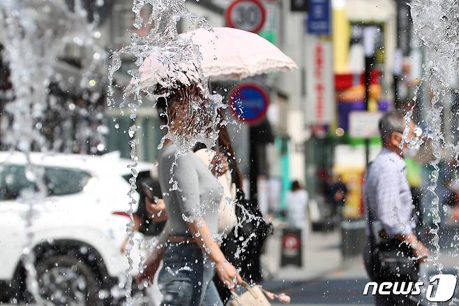 지난 17일 오후 3시 기준 대구의 낮 최고기온이 29.2도까지 올라가며 초여름 더위가 찾아온 가운데 양산을 쓴 시민들이 동성로 관광안내소 앞 분수대를 지나고 있다(사진은 기사와 무관). 2022.5.17/뉴스1 © News1