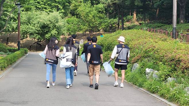 지난 21일 서울 보라매 공원에서 빗썸 직원들이 환경정화 봉사활동 플로깅을 진행하고 있다.
