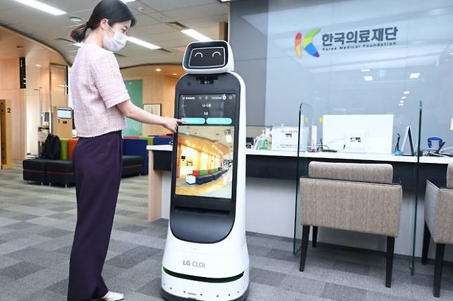 한국의료재단 종합검진센터 직원이 LG 클로이 가이드봇을 활용해 건강검진 안내를 받는 절차를 시연하고 있다. LG전자 제공