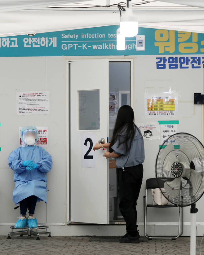 22일 서울 중랑구 보건소에 마련된 신종 코로나바이러스 감염증(코로나19) 선별진료소를 찾은 시민이 PCR(유전자증폭) 검사를 받기 위해 진료 부스로 들어서고 있다. 뉴스1