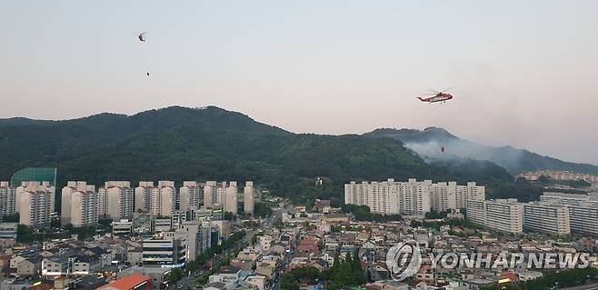 산불 진화하는 헬기 (김해=연합뉴스) 22일 오후 경남 김해시 구산동의 한 야산에서 산불이 발생해 산불진화헬기가 불을 끄고 있다. 2022.5.22 [독자 한수아 씨 제공. 재판매 및 DB 금지] hkm@yna.co.kr