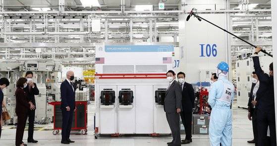 윤석열 대통령과 조 바이든 미국 대통령이 20일 경기 평택 삼성전자 반도체 공장을 방문해 반도체 생산라인을 둘러보며 관계자의 설명을 듣고 있다. 사진 왼쪽은 두 정상이 브리핑을 받는 동안 이재용 삼성전자 부회장이 지나 러몬도 미 상무장관과 별도로 대화를 나누는 모습. [대통령실사진기자단=뉴스1 오대일 기자]