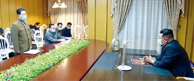 김정은 북한 국무위원장(오른쪽)이 지난 12일 국가비상방역사령부에서 덴털마스크를 쓰고 코로나19 확산 대응책 마련을 지시하고 있다. /연합뉴스