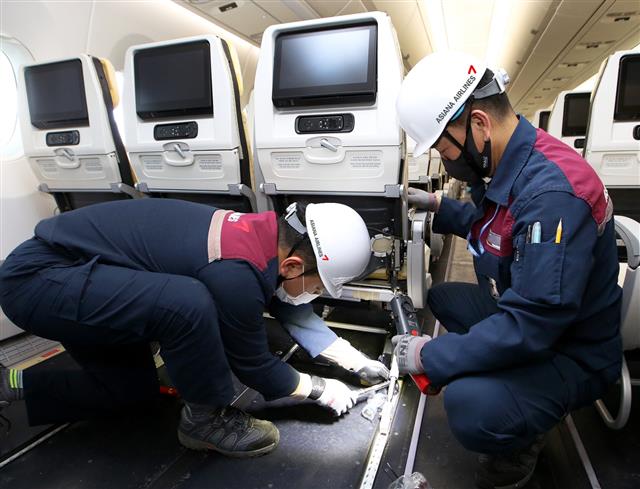 아시아나 ‘화물기 개조’ 여객기 원상 복원 - 23일 아시아나항공 정비사들이 화물기로 개조했던 A350 항공기에 좌석을 다시 장착하며 여객기로 원상 복원하는 개조 작업을 하고 있다.아시아나항공 제공
