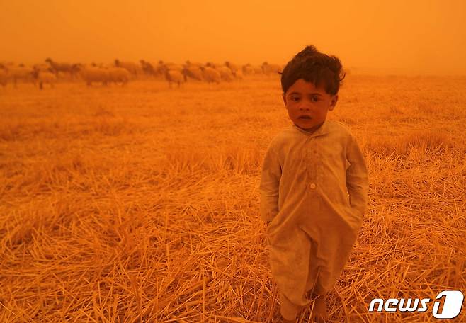 23일(현지시간) 이라크 남부 나자프 지역에서 한 어린이가 모래 폭풍 속에 서 있다. © AFP=뉴스1 © News1 김예슬 기자