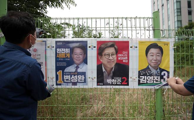 제8회 전국동시지방선거 공식 선거운동 첫날인 지난 19일 부산시 수영구 망미1동 행정복지센터 부근에서 수영구 직원들이 선거벽보를 부착하고 있는 모습. /뉴스1