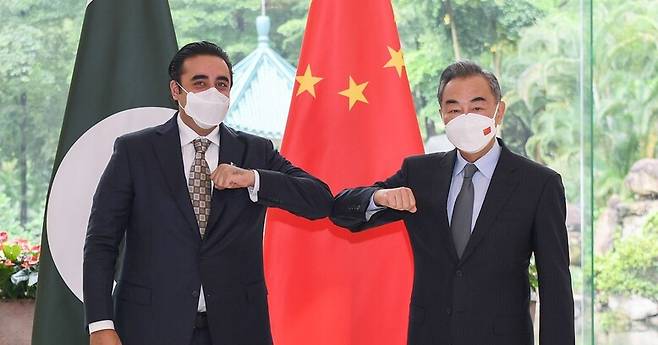 22일 중국 광저우에서 왕이 외교부장(오른쪽)과 빌라왈 부토 자르다리 파키스탄 신임 외교장관이 회담 뒤 팔꿈치를 맞대고 있다. 광저우/신화 연합뉴스