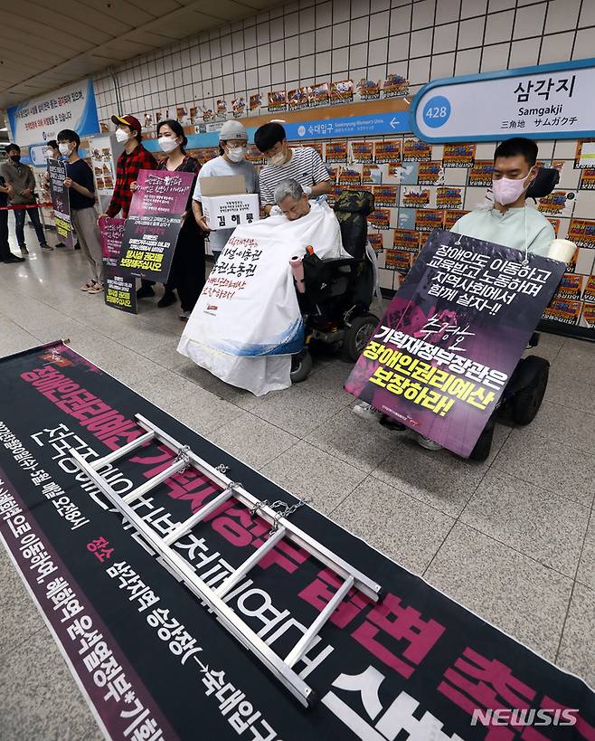 [서울=뉴시스] 이영환 기자 = 24일 오전 서울 용산구 지하철4호선 삼각지역에서 전국장애인차별철폐연대(전장연) 회원들이 장애인 권리예산 보장을 촉구하며 삭발 투쟁을 하고 있다. 2022.05.24. 20hwan@newsis.com