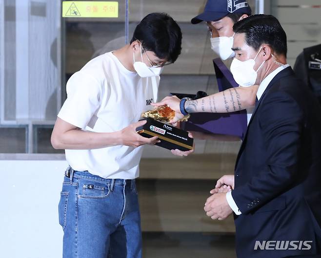 [인천공항=뉴시스] 김진아 기자 = 아시아 선수 최초로 잉글랜드 프로축구 프리미어리그(EPL) 득점왕에 오른 손흥민(토트넘)이 24일 오후 인천국제공항을 통해 귀국, 관계자에게 골든부트를 건네받고 있다. 2022.05.24. bluesoda@newsis.com