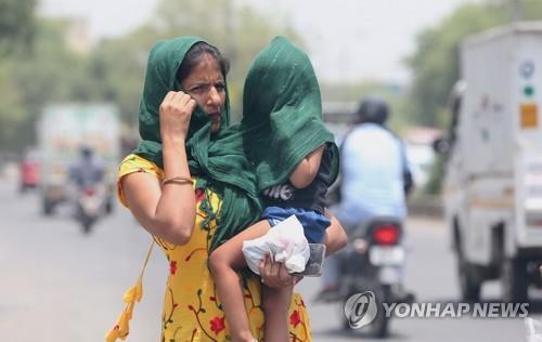 더위를 피하고자 안은 아이를 천으로 감싼 채 이동하는 인도 여성  [EPA 연합뉴스 자료사진. 재판매 및 DB 금지]