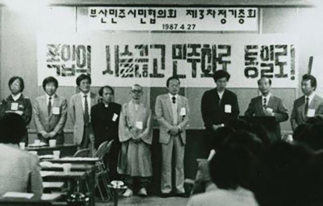 1987년 4월 27일 대연성당에서 열린 부민협 제3차 총회에서 관계자들이 기념사진을 찍고 있다. 왼쪽부터 황대봉 목사, 노무현 변호사, 문재인 변호사, 엄영일 성공회 신부, 소암 스님, 임정남 시인, 한 분 건너 최성묵 목사, 그 옆으로 두 분 건너 김상찬 선생. 노무현 사료관