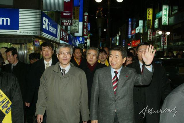 2002년 12월 14일 부산 광복동 유세 중 시민들 사이를 걸으며 유권자들에게 인사하는 노무현 민주당 대통령 후보와 문재인 국민참여운동 부산본부장. 노무현 사료관