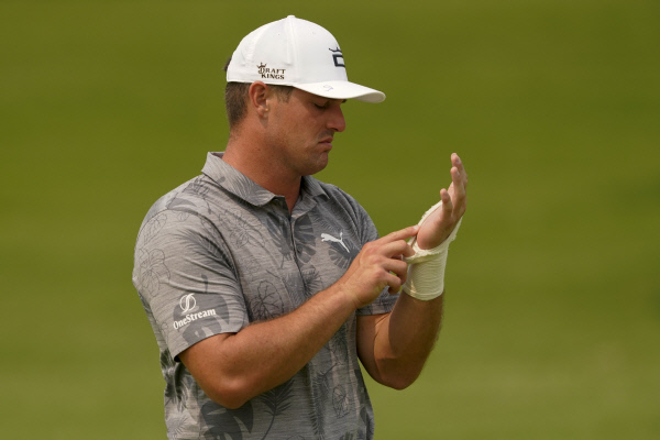 미국의 브라이슨 디섐보가 지난 18일(한국시간) 미국 오클라호마주 털사의 서던힐스컨트리클럽에서 PGA챔피언십을 앞두고 연습라운드를 하며 붕대를 감은 왼쪽 손목을 살피고 있다.  AP뉴시스