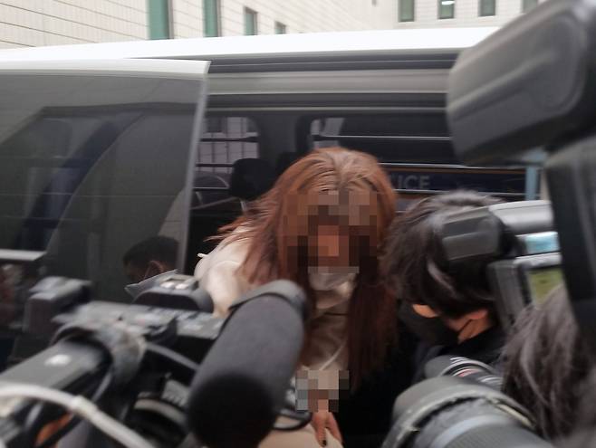 9호선 휴대전화 폭행 사건으로 구속된 20대 여성이 서울 강서경찰서 호송차에서 내리고 있다. 이 여성은 지난 16일 지하철 9호선 전동차 안에서 휴대전화로 60대 남성의 머리를 여러 번 내려친 혐의를 받고 있다. [연합]뉴스