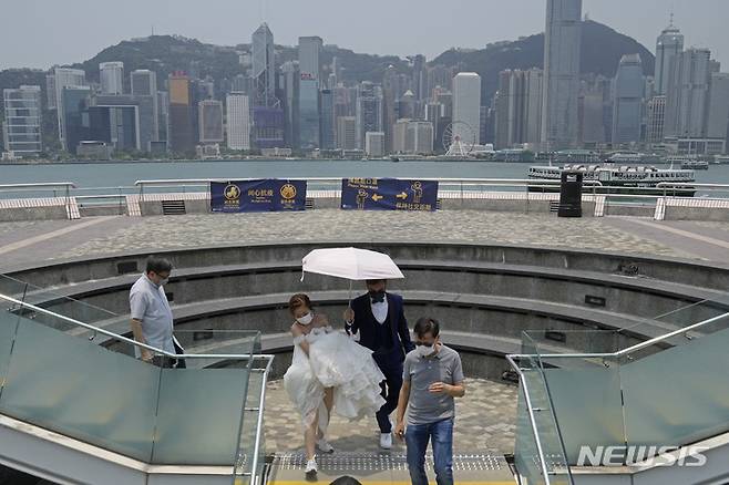 [홍콩=AP/뉴시스] 홍콩에서 21일 결혼을 앞둔 커플이 코로나19 예방을 위해 마스크를 착용한 채 웨딩촬영을 하고 있다. 2022.05.21
