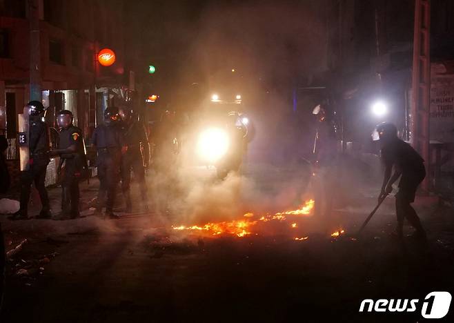 세네갈에서 벌어진 무력시위로 거리에 불이 났다. 경찰관들이 불을 진압하고 있다. © 로이터=뉴스1 © News1 이서영 기자
