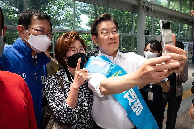 이재명 더불어민주당 계양을 후보(오른쪽)와 박남춘 인천시장 후보가 26일 인천 계양역 승강장에서 한 시민과 기념 촬영을 하고 있다. /뉴스1