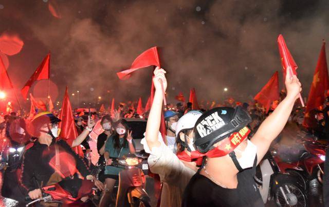 베트남 남자 축구 국가대표팀이 제31회 동남아시안게임에서 금메달을 딴 지난 22일, 결승전이 진행된 하노이 미딩 국립경기장 앞 대로에 베트남 국기를 든 수많은 시민들이 오토바이를 타고 '베트남'을 연호하고 있다. 하노이=정재호 특파원