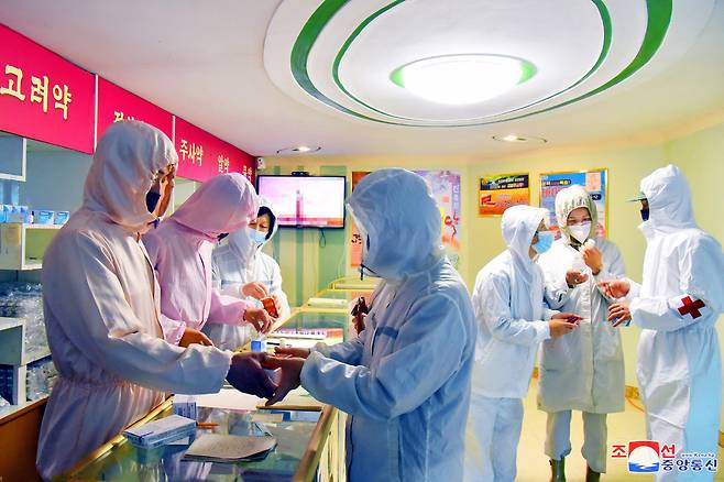 A photo released by the North Korean Central News Agency (KCNA) on 20 Mayshows medical service personnel in the military handing out medical supplies at a pharmacy to curb the current coronavirus disease health crisis in Pyongyang, North Korea. (Yonhap)