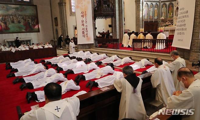 [서울=뉴시스] 사진공동취재단 = 28일 서울 중구 명동성당에서 열린 천주교 서울대교구 사제 서품식에서 사제 수품 후보자들이 세상에 죽고 하느님께 봉사하겠다는 것을 드러내기 위해 부복하고 있다. 2022.01.28. photo@newsis.com