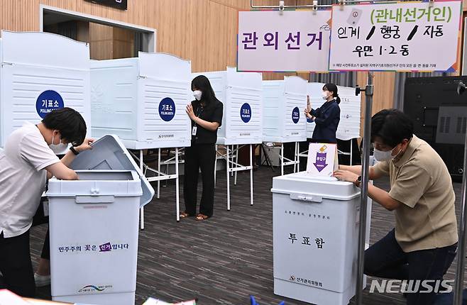 [수원=뉴시스] 김종택 기자 = 제8회 전국동시지방선거 사전투표를 하루 앞둔 26일 오후 경기도 수원시청 별관에서 관계자들이 사전투표소를 설치하고 있다. 2022.05.26. jtk@newsis.com