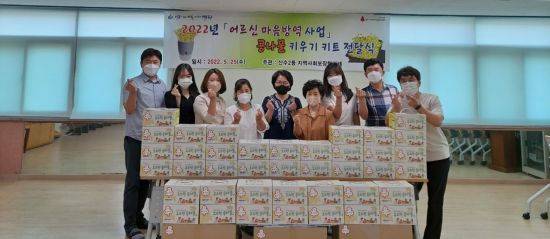 25일 광주광역시 동구 산수2동 지역사회보장협의체는 독거 어르신 40가구에 콩나물 기르기 꾸러미를 전달하고 있다. 사진=광주 동구청 제공.