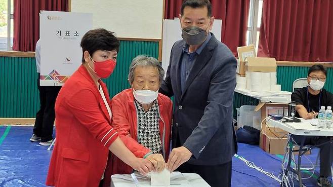 국민의힘 최원철(오른쪽) 후보가 아내, 구순의 노모와 함께 자신의 고향 유구 석남리 유구초등학교에 마련된 사전투표소에서 투표하고 있다.