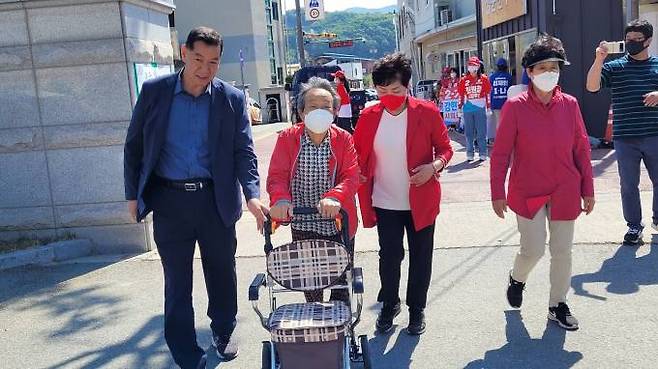 최원철 공주시장 후보가 가족과 함께 노모를 모시고 사전투표장에 들어서고 있다.