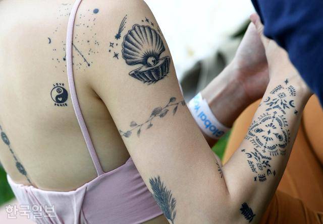 한 참가자가 'LOVE'와 'PEACE' 등 다양한 형태의 타투를 몸에 새긴 채 요가 준비를 하고 있다.