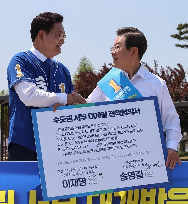 이재명(오른쪽) 더불어민주당 상임고문과 송영길 서울시장 후보가 지난 27일 경기 김포시 고촌읍 아라 김포여객터미널 아라마린센터 앞 광장에서 열린 김포공항 이전 수도권 서부 대개발 정책협약식에서 악수하고 있다. 국회사진기자단