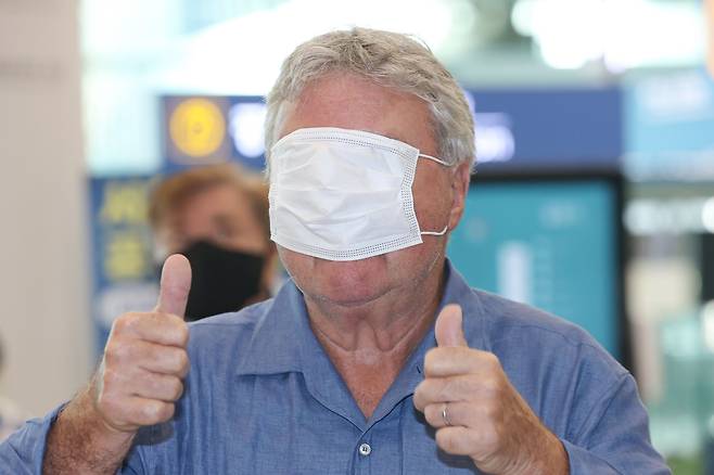 히딩크 감독이 28년 인천국제공항을 통해 입국하며 마스크로 얼굴을 가리는 장난을 치고 있다. /연합뉴스