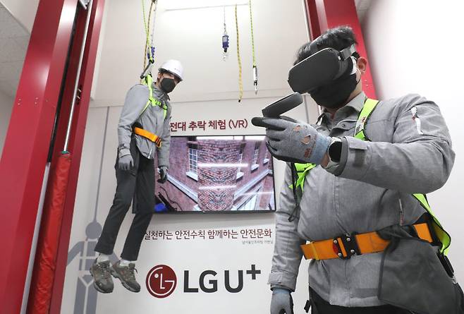 네트워크 안전체험관에서 LG유플러스 소속 교육생들이 안전대를 착용하고 VR로 추락사고를 체험을 하고 있는 모습.