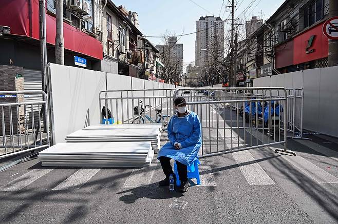 지난 3월 봉쇄 조치가 이뤄진 중국 상하이시에서 방호복을 입은 방역 요원이 출입을 막고 있다. [AFP=연합뉴스]