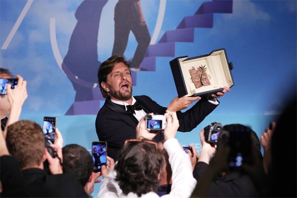 황금종려상을 수상한 루벤 외스틀룬드 감독이 관중들에게 트로피를 보이고 있다. [EPA = 연합뉴스]