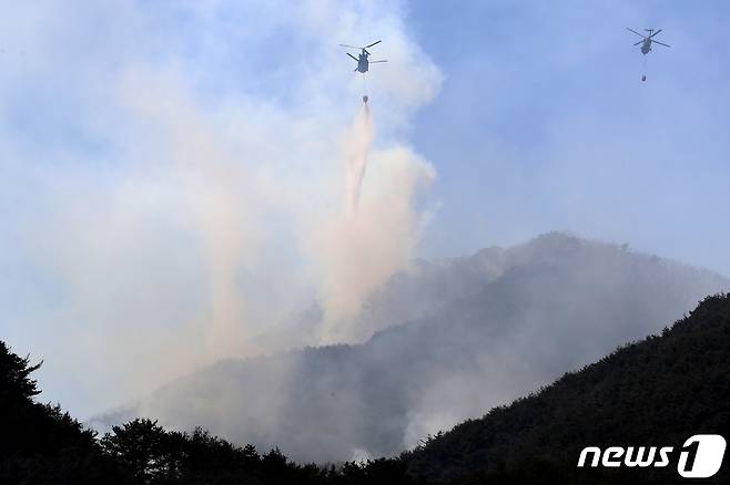 지난 3월2일 오후 대구 달성군 가창면 주암산 산불 진화에 투입된 소방·산림청·국방부 헬기가 번갈아 물을 퍼붓고 있다.  2022.3.2/뉴스1 © News1 공정식 기자