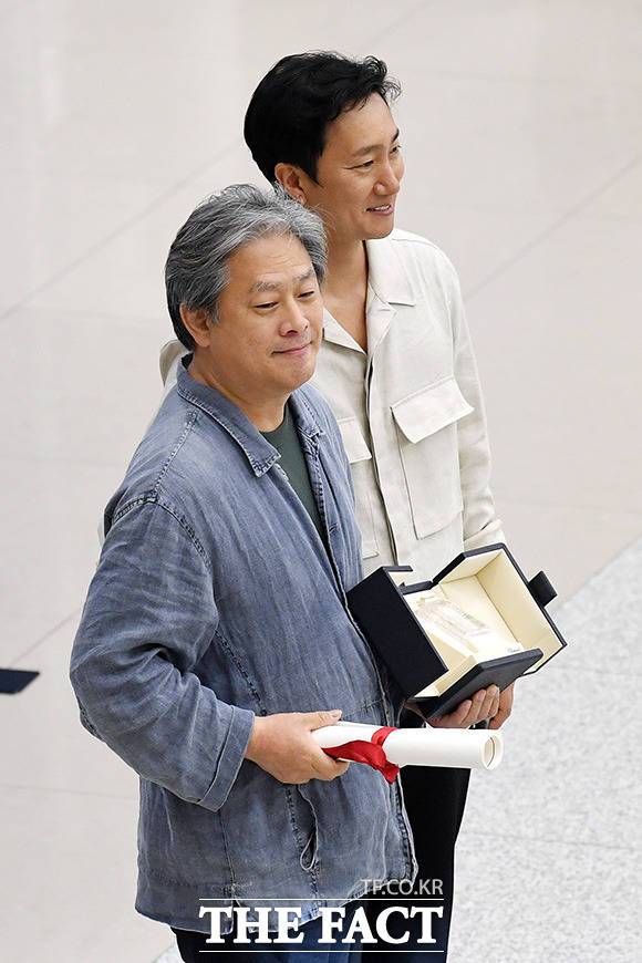 영화 '헤어질 결심'으로 제75회 칸 국제영화제에서 감독상을 수상한 박찬욱 감독(왼쪽)과 배우 박해일이 30일 오후 인천국제공항을 통해 귀국하며 기념촬영을 하고 있다. /인천국제공항=남용희 기자