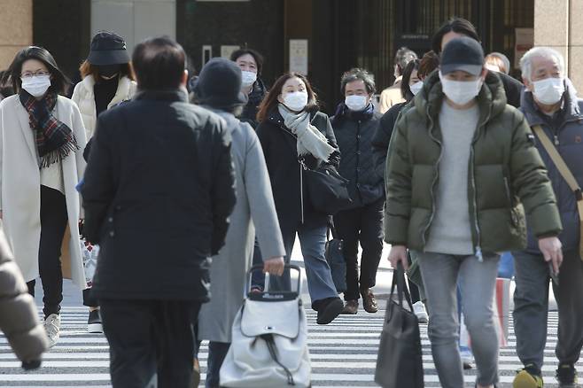 2022년 2월 7일 일본 도쿄에서 코로나19 확산 방지 마스크를 쓴 시민들이 길을 걷고 있다. 일본 정부는 이달 중 하루 100만회 접종 체제를 구축한다는 방침이다. /연합뉴스