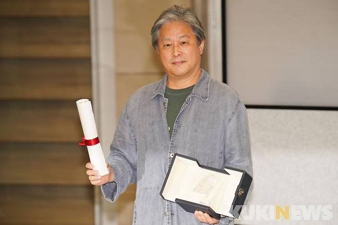 30일 오후 인천국제공항 제2여객터미널로 입국한 박찬욱 감독이 제75회 칸영화제 감독상 트로피를 들고 포즈를 취하고 있다.&nbsp; &nbsp;사진=임형택 기자