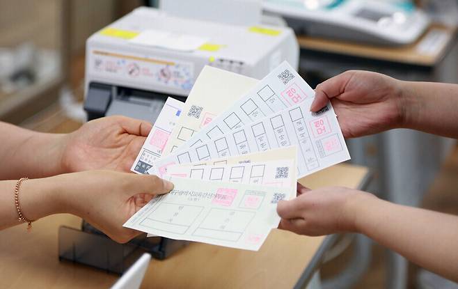 6·1 지방선거 사전투표를 하루 앞둔 지난 26일 대구 동구 효목2동 행정복지센터에 마련된 사전투표소에서 관계자들이 투표업무 최종 테스트를 하고 있다. 연합뉴스