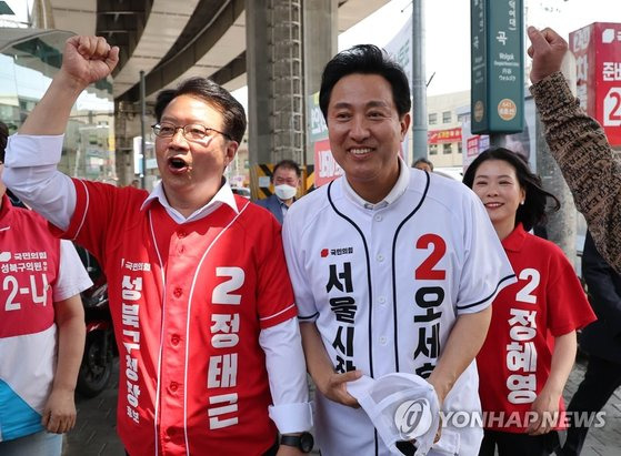 국민의힘 오세훈 서울시장 후보(가운데)가 31일 서울 성북구 월곡역 앞에서 열린 유세장으로 정태근 성북구청장 후보(왼쪽)의 안내를 받아 이동하고 있다. 연합뉴스