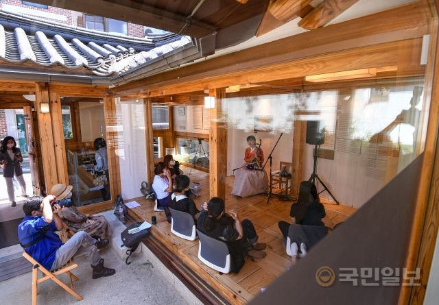 31일 서울 종로구 북촌한옥역사관에서 '북촌 툇마루 기행'이 진행되고 있는 가운데 방문객들이 해금 연주자 '은한'의 공연을 감상하고 있다.