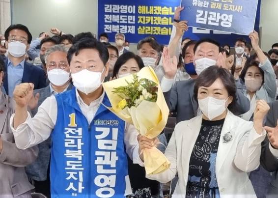 ▲김관영 전북도지사 당선인과 부인이 1일 오후 개표방송을 지켜보며 1위가 확정되자 축하의 꽃다발을 들고 주먹을 쥐어 보이고 있다. ⓒ프레시안