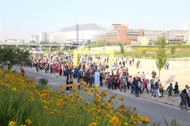 서울 구로구가 2019년 진행한 ‘안양천 사랑 가족건강 걷기대회’ 행사에 참여한 주민들이 함께 걷고 있다.구로구 제공