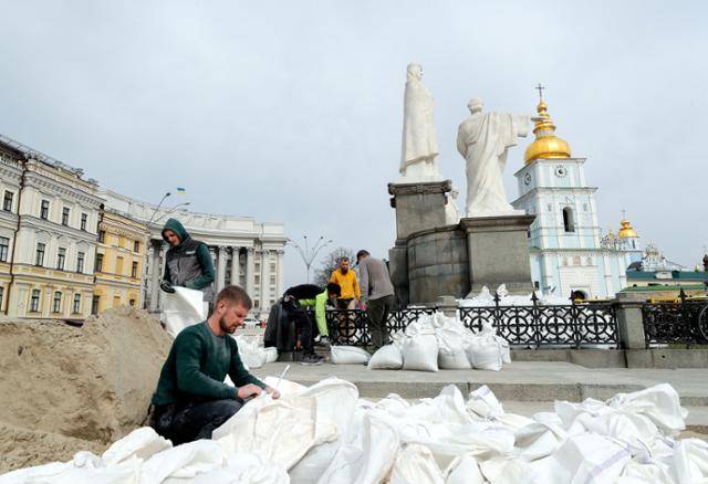 우크라이나 수도 키이우에서 3월 26일 자원봉사자들이 러시아군의 공격에 대비해 올가 여공 동상을 모래주머니로 감싸고 있다. 키이우=EPA 연합뉴스